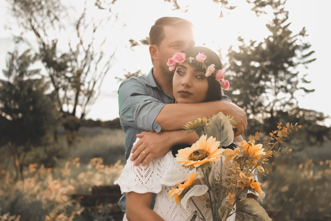 a bride and groom embracing in the sunlight