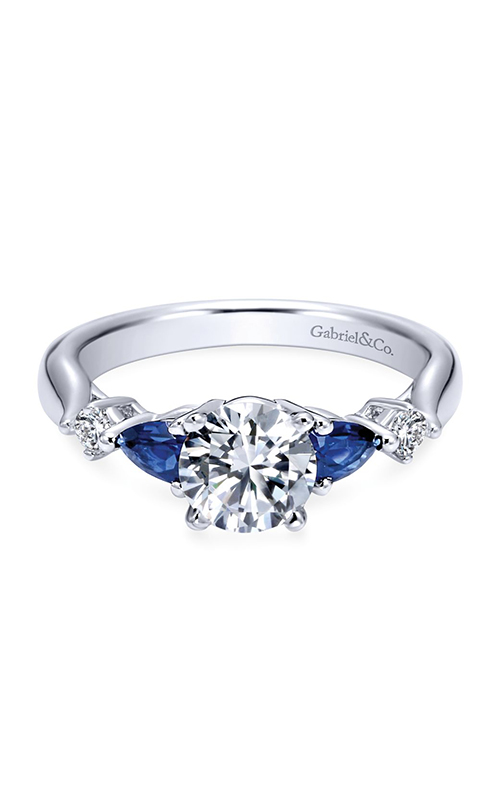 A white gold three stone engagement ring with blue sapphires and centre round cut diamond