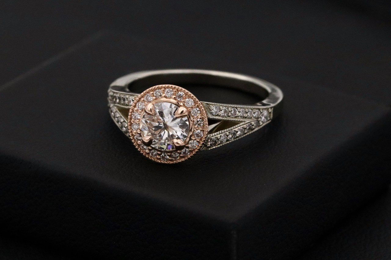 A mixed metal engagement ring with milgrain detailing 