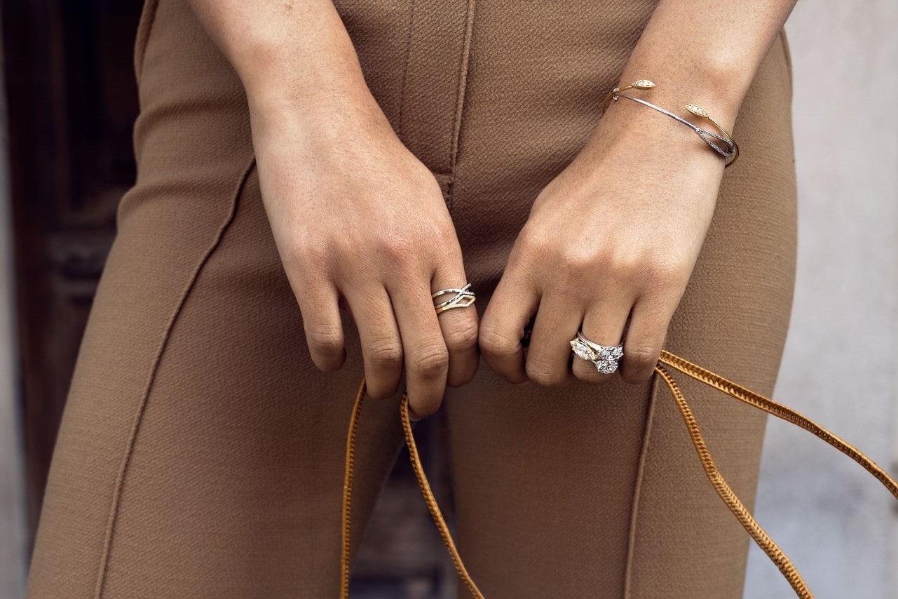 Lady holding a bag, wearing fashion rings on both hands