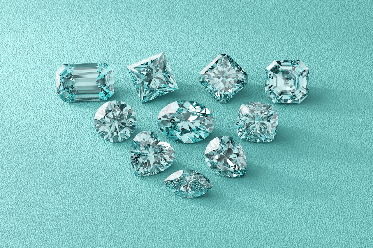 A variety of lab-grown diamonds showcases all the popular gem cuts as they sit on a teal leather fabric