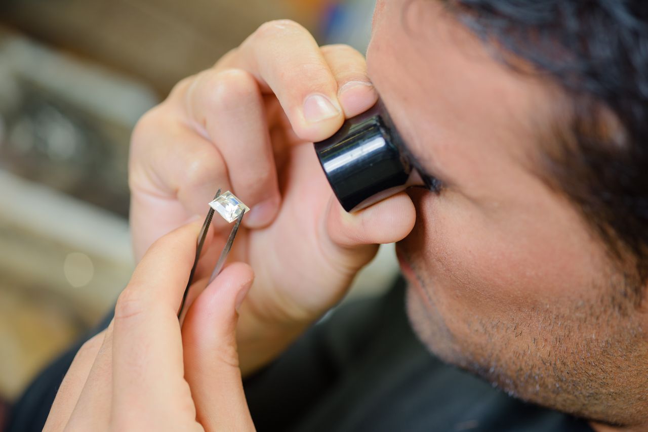 An expert gemologist inspects a princess-cut lab-grown diamond for perfection before placing it in a ring setting