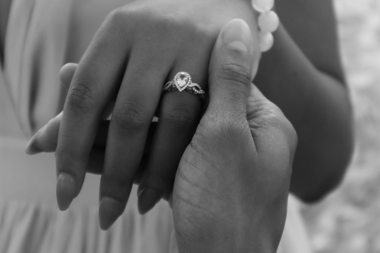 A pear shaped diamond surrounded by a halo of diamonds and an interweaving band