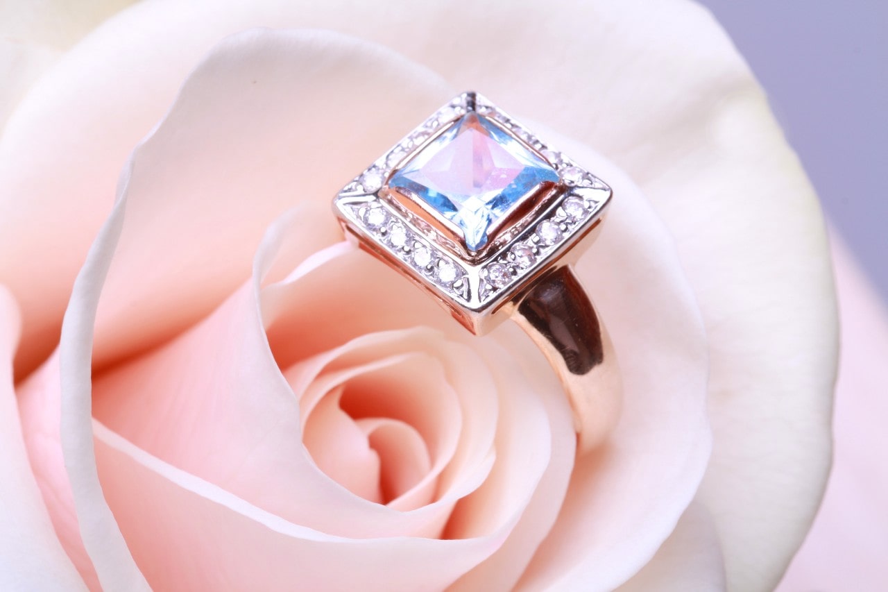 Princess cut diamond ring on a pink rose