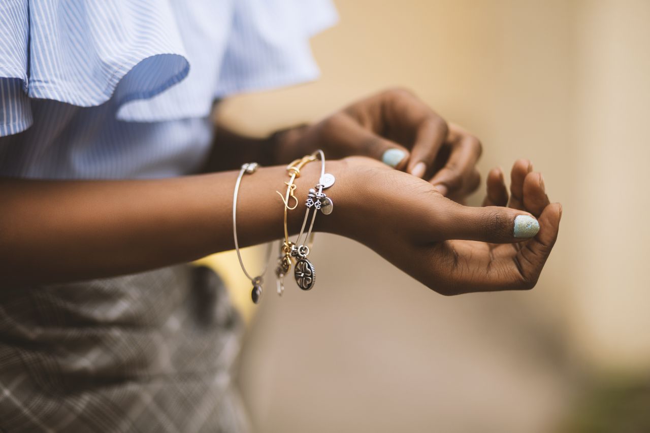 Chic individual wearing an assortment of slender charm bracelets