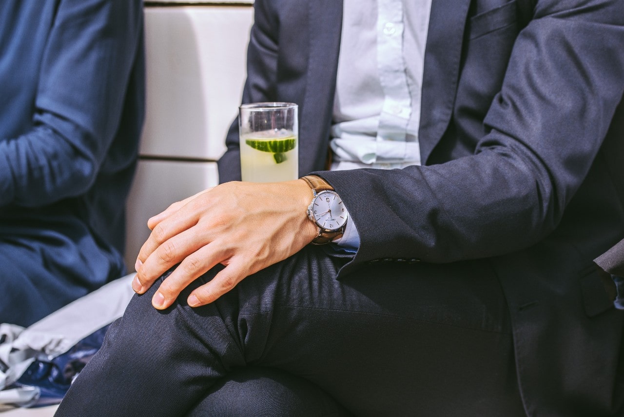 A watch-wearing dad sips a limeade on his lunch break from work