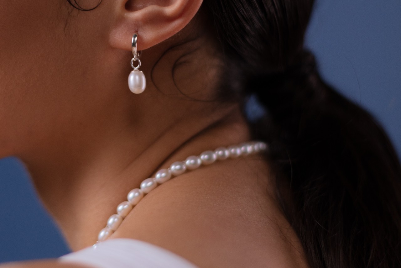 A woman wearing a pearl necklace and earrings