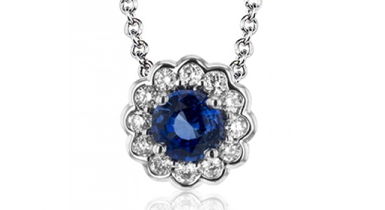 A sapphire pendant necklace surrounded by diamond accents that give it a floral silhouette