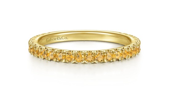 A gold stacking ring lined with round cut citrines