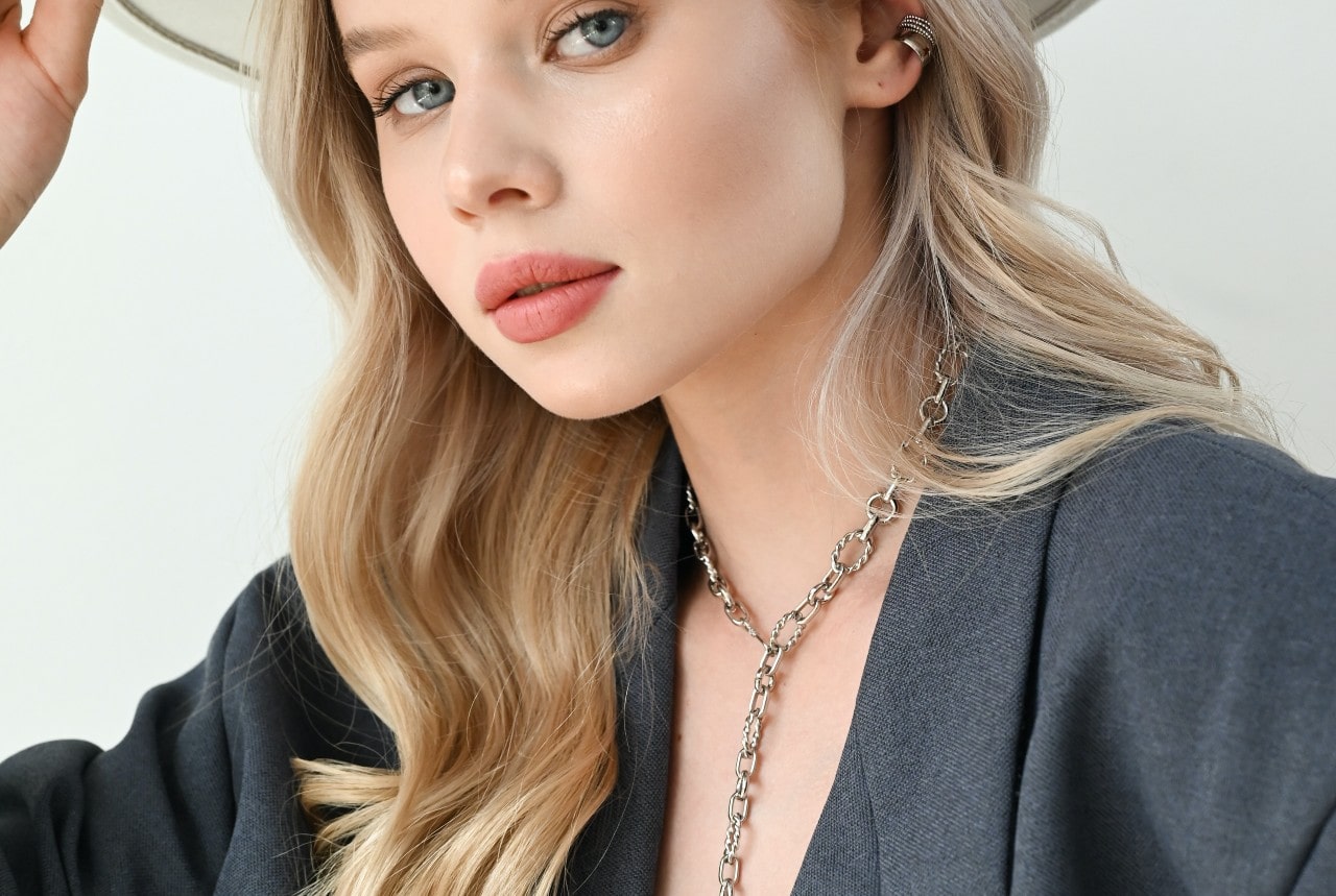 A woman wearing a sunhat sports a chunky chain lariat necklace