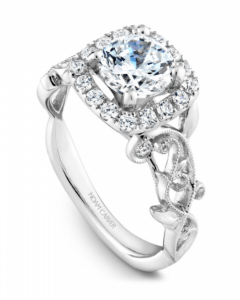 A side view of a Noam Carver Floral white gold halo engagement ring.