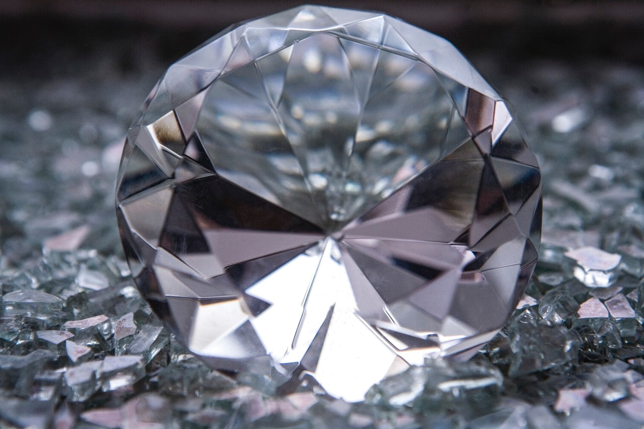 close up image of a round cut diamond sitting among diamond shards